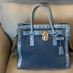 Blue denim authentic Michael Kors purse and wristlet with gold hardware.